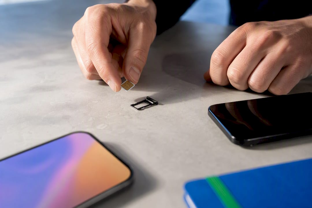 Fysieke simkaart naast een anonieme smartphone