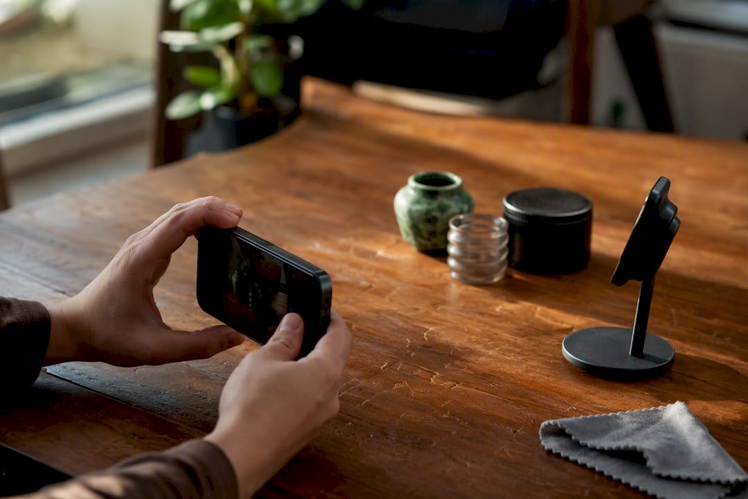 Iemand houdt een smartphone vast en maakt zich klaar om een proefopname te maken.